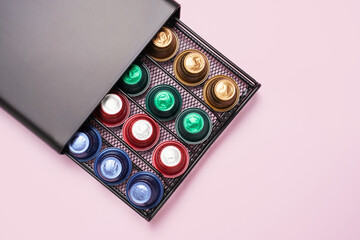 Box with multi-colored capsules for coffee machine close-up, top view.