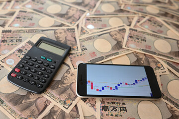大量の一万円札と為替相場のチャート　10,000 yen bills and a chart of the exchange rate