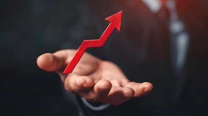 Businessman's hand holding falling arrow, depicting investment loss and economic downturn.