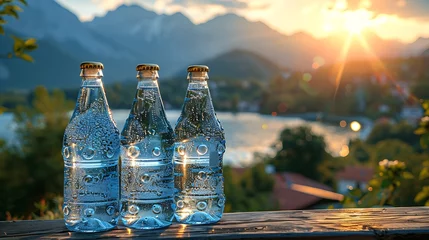 Rollo Bottles and glasses of pure mineral water with a mountain landscape in the background © Anditya