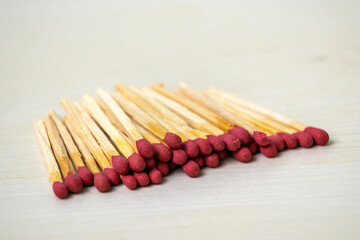 A pile of match sticks on wooden background. It is a short, slender piece of flammable wood used in...