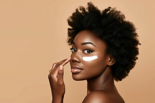 A woman with a tan complexion is applying makeup to her face. She has a confident and beautiful expression on her face