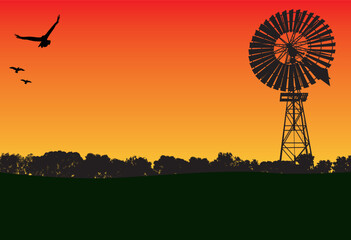 windmill in the sunset and lots of silhouette of trees in the foreground