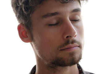A close-up portrait of a young man with closed eyes