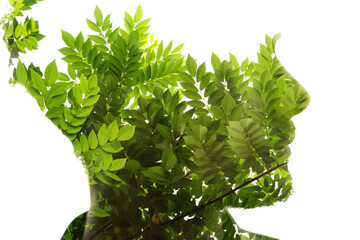 A double exposure male profile silhouette portrait combined with green leaves