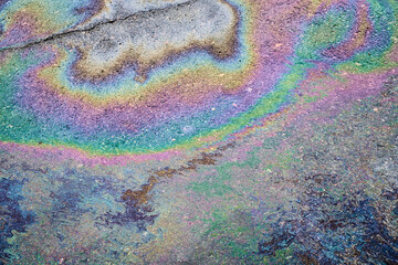 Textured stain of fuel or oil on wet asphalt on a rainy day. The concept of environmental pollution