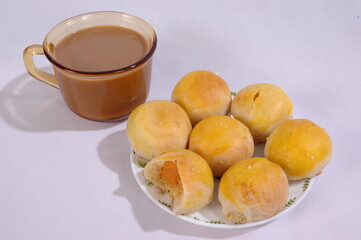 Tau Sar Piah with Sweet green been and Sweet black seeds and salted egg on a white background with a cup of hot milk tea
