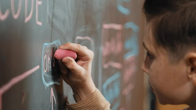 Closeup of smart student or boy writing prompt on blackboard. Child plan project and setting engineering system and brainstorm creative idea wrote on blackboard. Focus on hand. Site view. Erudition.