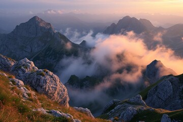 Majestic mountain peaks emerging from soft clouds at sunrise, with warm light illuminating the rugged landscape.