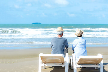 Asian Lifestyle senior couple hug and sitting on the beach happy in love romantic and relax time. ...