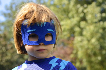 Little boy in a superhero costume and mask. Costume party, carnival, masquerade, Halloween, Purim.