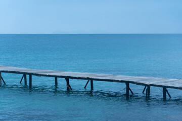 Fototapeta na wymiar wooden bridge on the blue sea natural background