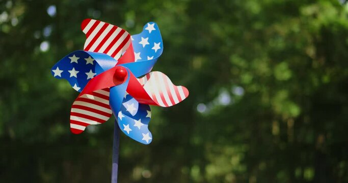 Spinning pinwheel with red, white, and blue stars and stripes like the US American flag. Outside fun for USA patriotic holidays like 4th of July, Memorial day, or other patriotic celebrations.