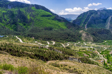 Amazing spring landscape in mountainous area. Mountains, valley and serpentine road from Gunib to Karadakh in Dagestan, Russia. Wonderful nature, beautiful natural background. Picturesque scenery