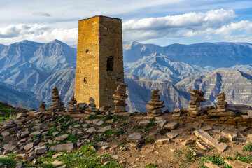 Stone pyramids against amazing landscape with mountain range and old tower. Wonderful nature,...