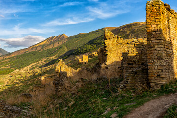 Old ruined aul against amazing landscape with mountain slope at sunset. Ancient caucasian village Goor, Dagestan republic, Russia, Caucasus. Famous place, popular landmark