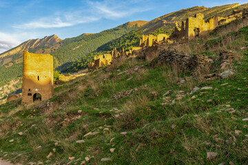 Goor towers and old ruined aul against amazing landscape with mountain slope at sunset. Ancient caucasian village Goor, Dagestan republic, Russia, Caucasus. Famous place, popular landmark