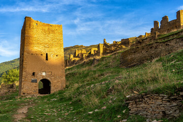Goor towers and old ruined aul against amazing landscape with mountain slope at sunset. Ancient caucasian village Goor, Dagestan republic, Russia, Caucasus. Famous place, popular landmark