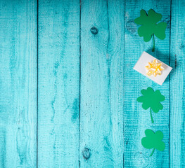 Green clover leaves and giftboxes on a wooden backgaund. St. Patricks postcard with copyspace....