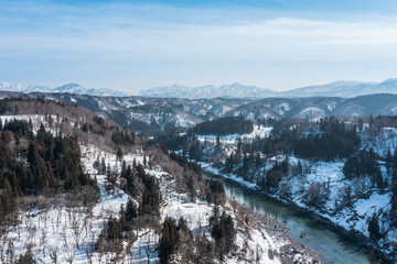 Fototapeta na wymiar ドローン写真：晴れた日の美しい雪山と千曲川の風景