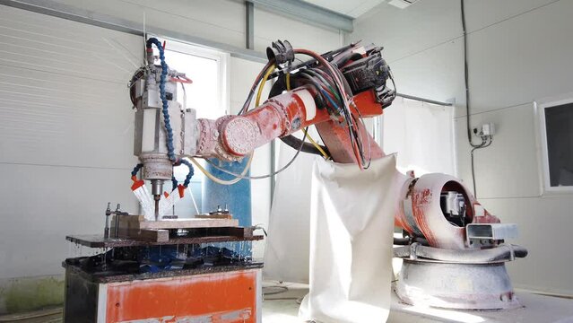 Slow motion view of robot working on milling sculpture in natural stone