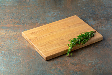 Cutting board and rosemary on a rusty iron table.