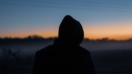 silhouette of a person at sunset - obrazy, fototapety, plakaty
