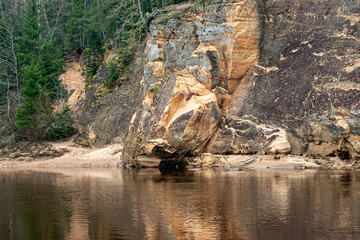 landscape with sandstone cliffs on the river bank, sandy river bank, old last year's grass, nature...