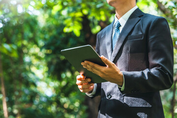 Business man using tablet to analyze ESG concept ,Sustainable development goal (SDGs) Ideas Globe Glass energy-based green business can limit climate change and global warming.