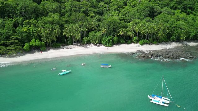 Timelapse aerial view of the Pacific Ocean waves and boats on Vivos Beach in Puntarenas, Costa Rica