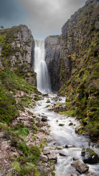 Wailing Widow Falls in Assynt, Waterfall in the forest, long exposure image, on the NC500 driving route Scotland, mobile wallpaper portrait.