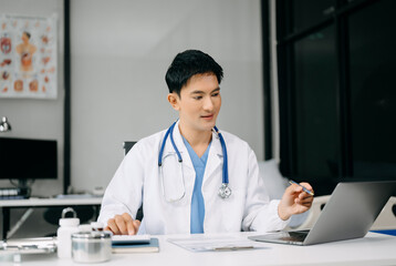 Doctor sit on table in office hospital. Attractive therapist female practitioner pharmacist smile and use tablet and laptop. after success work from treatment