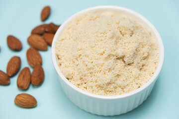 Almond flour and almonds on a light blue background