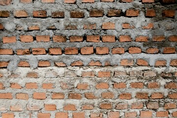 Rustic orange and gray textured brick wall, exuding an urban vintage feel, often used as a design backdrop or for architectural subjects.