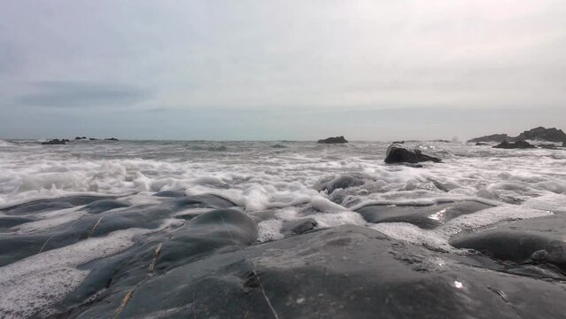 Waves incoming on flat rocks beach level Copper Coast Waterford Ireland