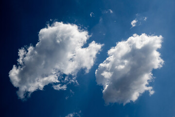 Two white fluffy clouds in the dream blue sky