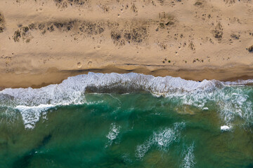 Aerial view of ocean waves washing a sandy shoreline
