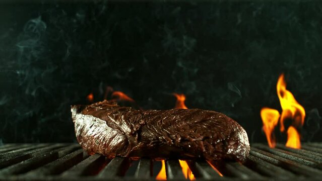 Super Slow Motion of Falling Beef Steak on Grill. Filmed on High Speed Cinema Camera, 1000 fps. Isolated on Black Background.