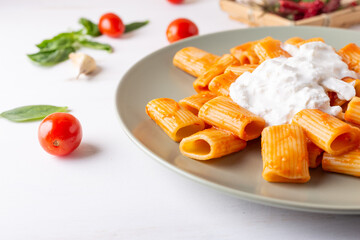 Macaroni with tomato sauce and stracciatella. Good and balanced Italian cuisine dish