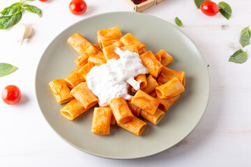 Macaroni with tomato sauce and stracciatella. Good and balanced Italian cuisine dish