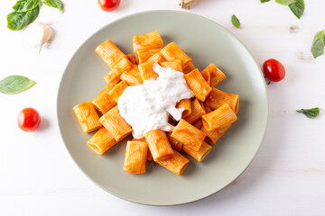 Macaroni with tomato sauce and stracciatella. Good and balanced Italian cuisine dish