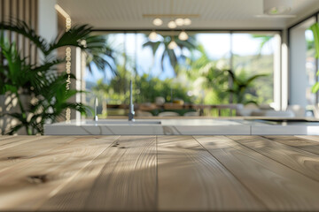 A closeup of an empty wooden table with a blurred background of modern kitchen interior design in tropical style, featuring white cabinets and glass windows overlooking the garden.