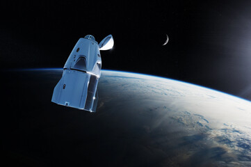 Cargo spacecraft in low-Earth orbit with sunlight. Elements of this image furnished by NASA. © Paopano