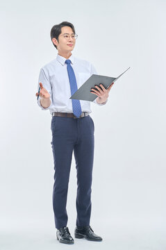 A young office worker man wearing a suit and glasses is holding a document file and posing with a variety of confident expressions.