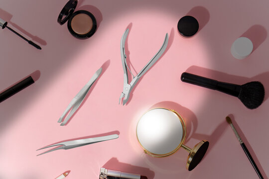make up products and tools on pink background