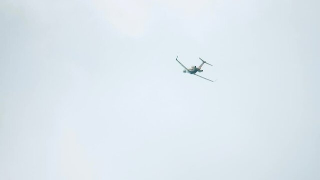 Ascending private jet flies away on grey sky background
