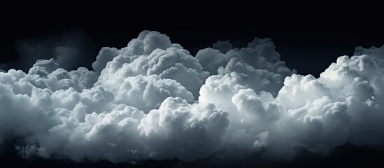 A cumulus cloud gracefully floats in the electric blue sky against a dark background, creating a...