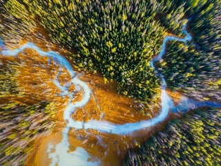 A drone view of the river in the woods. An aerial view of the forest. Winding river among the trees. Turquoise mountain water. Landscape with soft light before sunset. - 766236155