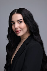 Fototapeta premium Beautiful woman in black jacket on gray background