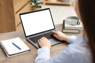 Fototapeta na wymiar E-learning. Woman using laptop during online lesson indoors, closeup
